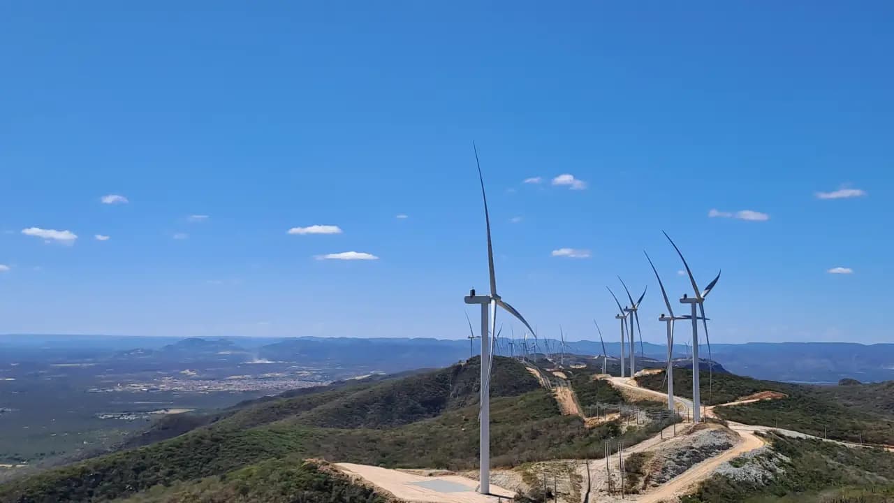 Parque eólico panorâmico com turbinas e infraestrutura de segurança