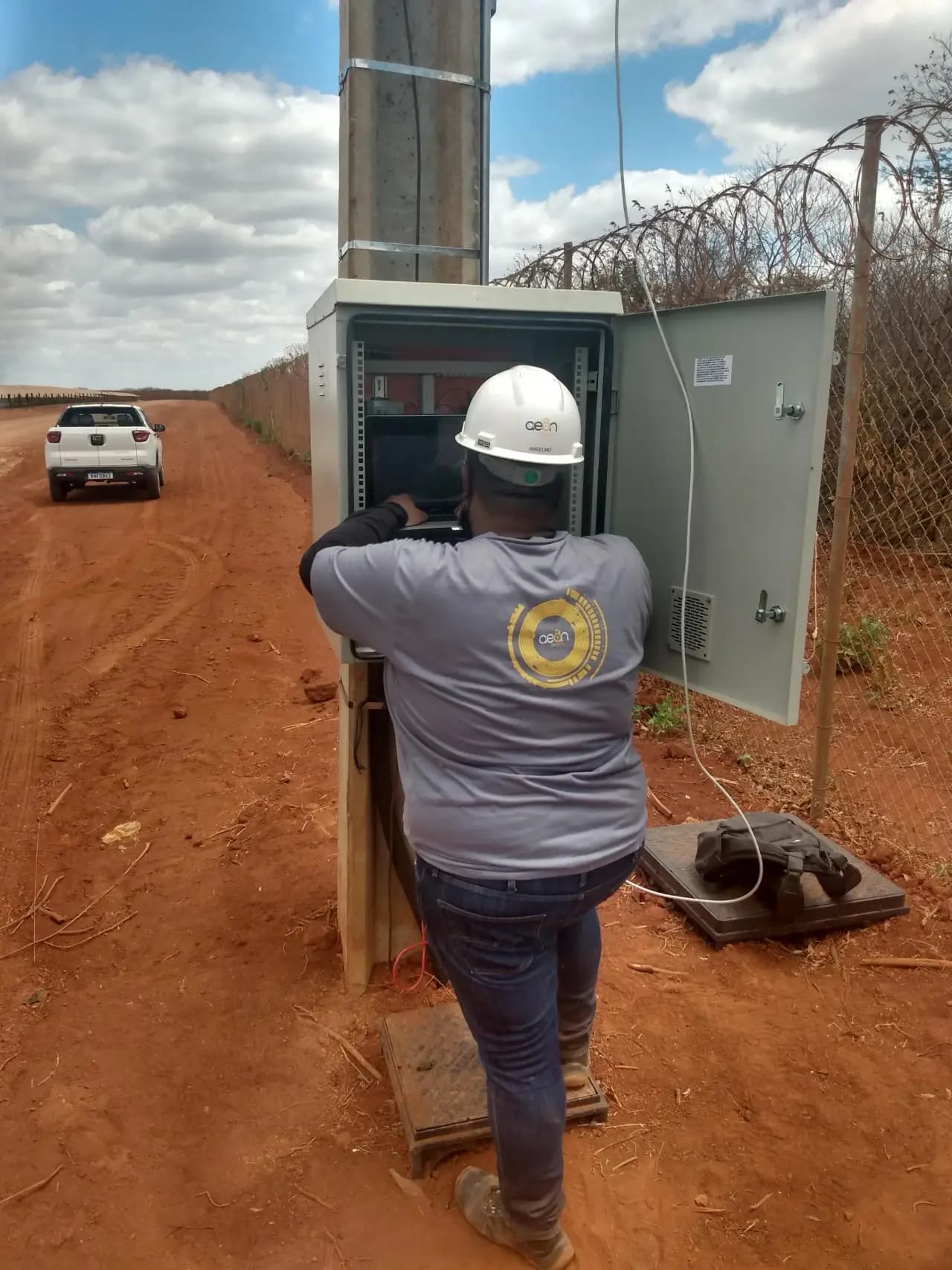 Técnico configurando equipamentos em rack de segurança eletrônica